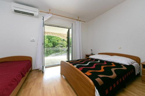 Schlafzimmer mit einem Bett und einer Glasschiebetür in der Unterkunft Apartments by the sea Zivogosce - Porat, Makarska - 20820 in Igrane