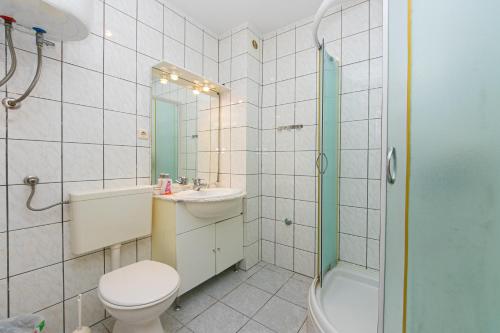 ein Bad mit einem WC, einem Waschbecken und einer Dusche in der Unterkunft Apartments by the sea Zivogosce - Porat, Makarska - 20820 in Igrane