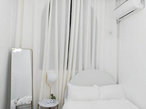 Habitación blanca con espejo y cama en Cactus villa 2, en General Santos