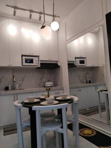 a kitchen with white cabinets and a table and chairs at Cactus villa 2 in General Santos