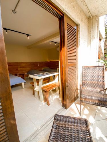 a balcony with a table and a bench on a patio at Villa'l Mare Hotel in Maresias
