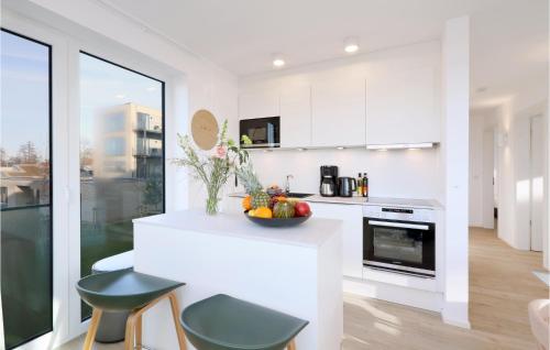 eine weiße Küche mit einer Schale Obst auf der Theke in der Unterkunft Cozy Apartment In Lembruchdümmer See in Lembruch