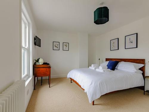Un dormitorio con una gran cama blanca y una ventana en The Old Guest House, en Margate