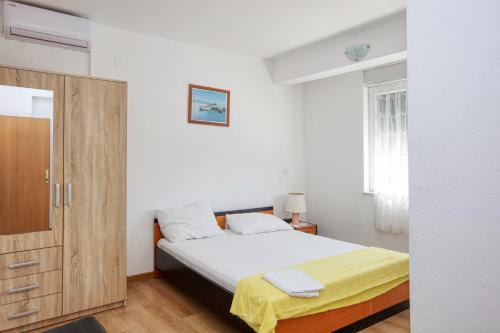 - une chambre avec un lit et une armoire en bois dans l'établissement Apartments by the sea Stupin Celine, Rogoznica - 21279, à Rogoznica