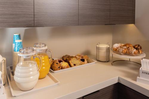 a kitchen counter with bread and milk and cookies at Marina Beach Motel in Santa Barbara