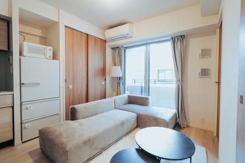 sala de estar con sofá y mesa en n'estate Kagurazaka, en Tokio