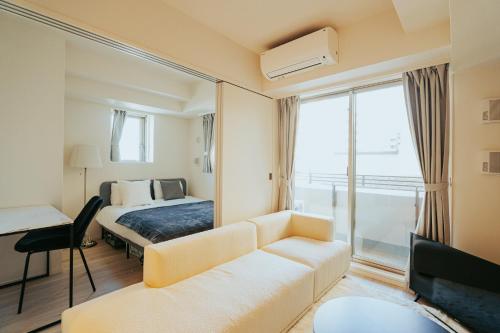une chambre d'hôtel avec un canapé et un lit dans l'établissement n'estate Kagurazaka, à Tokyo