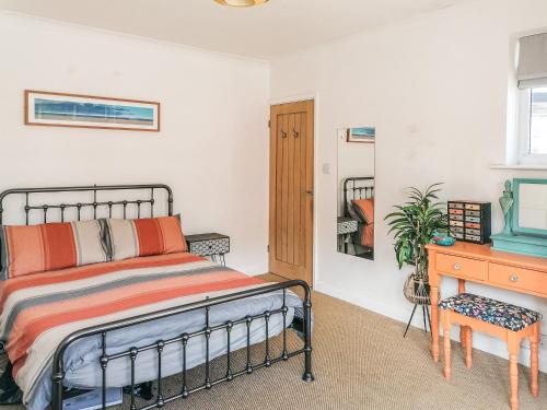 a bedroom with a bed and a desk at Palm View in Paignton