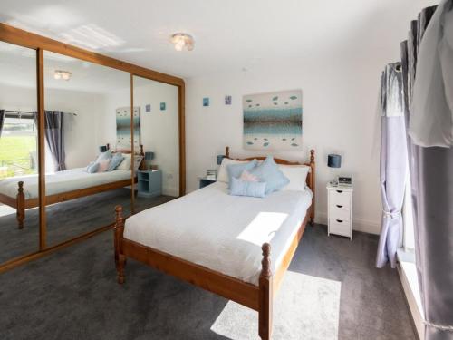a bedroom with a bed and a large mirror at Bunny Meadows in Banc-y-felin