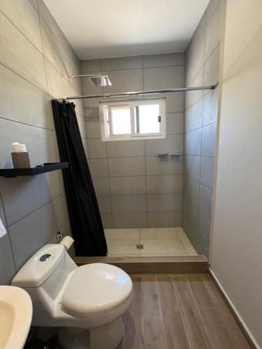 a bathroom with a shower and a toilet and a sink at Habitación Cedros en Palmerola, Comayagua in Comayagua