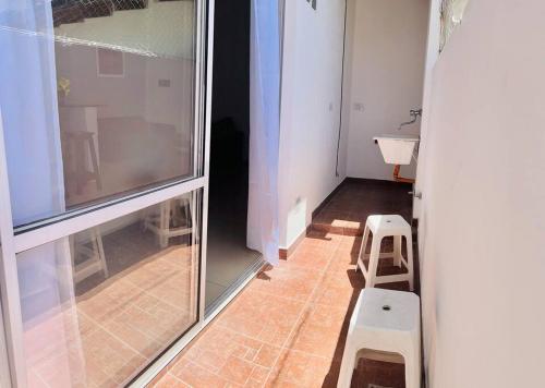 a room with a large glass window and two stools at Asombroso departamento en CABA con patio in Buenos Aires