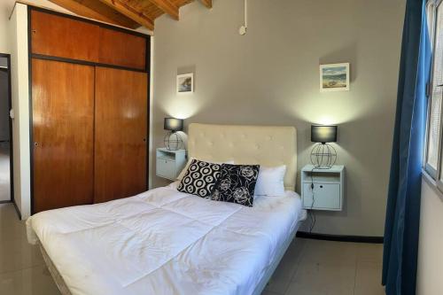 una camera con letto bianco e testiera in legno di Asombroso departamento en CABA con patio a Buenos Aires