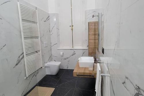 a white bathroom with a toilet and a sink at Amazing Villa in Migliarino in Migliarino