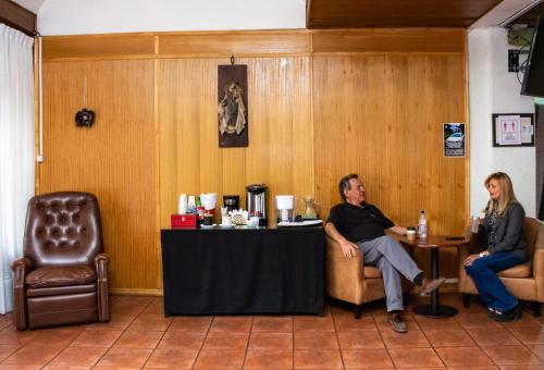 a man and a woman sitting at a table in a room at Hotel Gran Muso in Los Ángeles