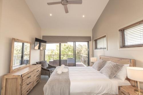 a bedroom with a large bed and a balcony at Bogong Lakeview 1 of 19 Bogong Street in Jindabyne