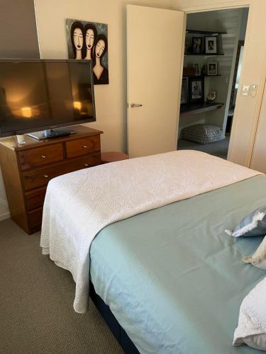 een slaapkamer met een bed en een flatscreen-tv bij Walk to Palmer B&B - U21 in Townsville