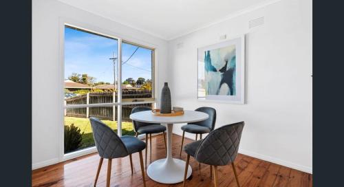 a dining room with a table and chairs and a window at Comfy bed quiet neighbourhood in Grovedale