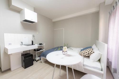 a small bedroom with a bed and a white table at 9stay蔵前 in Tokyo