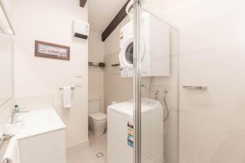 y baño con ducha, aseo y lavamanos. en Lake Pines 2 of 24 Cobbon Crescent Free WiFi and Stay 7 nights only pay 6 en Jindabyne