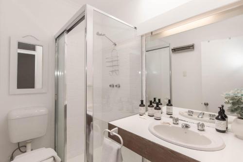 Un baño blanco con lavabo y ducha. en Montebello 3 12 Cobbodah Street, en Jindabyne