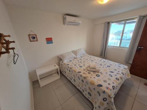 a small bedroom with a bed and a window at Vela e Mar in João Pessoa