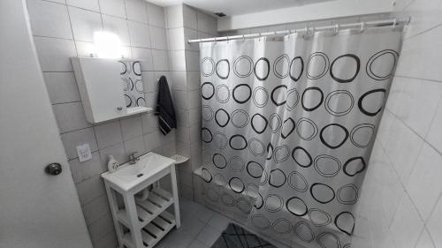 ein Bad mit einem Duschvorhang und einem Waschbecken in der Unterkunft Departamento en pleno centro Don Bosco 73 in Mendoza