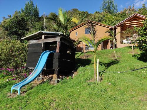 a playground with a blue slide in a yard at La Casita de Chocolate 2 in Bogotá