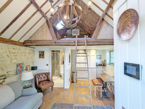 a living room with a vaulted ceiling and a ladder at Holme Street House and Dove Cote Lodge in Pulborough