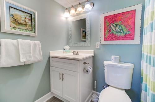 a bathroom with a toilet and a sink and a mirror at 0812 Destination Bliss by Atlantic Towers in Carolina Beach