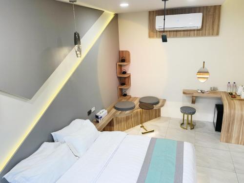 a bedroom with a bed and a table and a kitchen at 日月對白 日月潭 2024全新開幕 in Yuchi