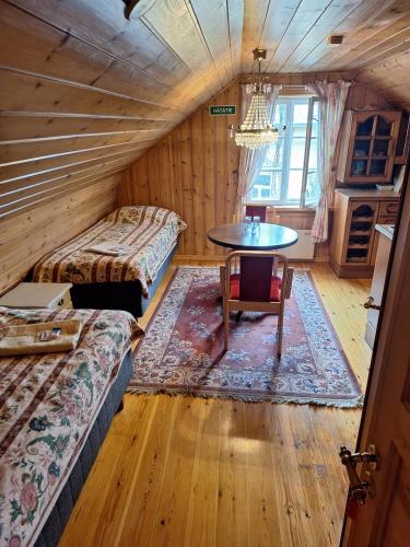 a room with two beds and a table in it at Hotelli Luostarin Puutarha in Naantali