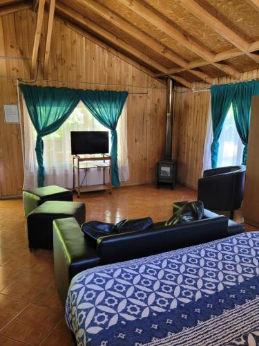 a room with couches and a bed and a piano at Cabañas Aguas Claras in Pinto