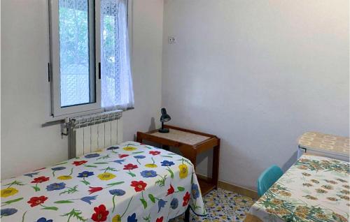 a bedroom with a bed and a window and a table at 1 Bedroom Lovely Home In Barano Dischia in Ischia