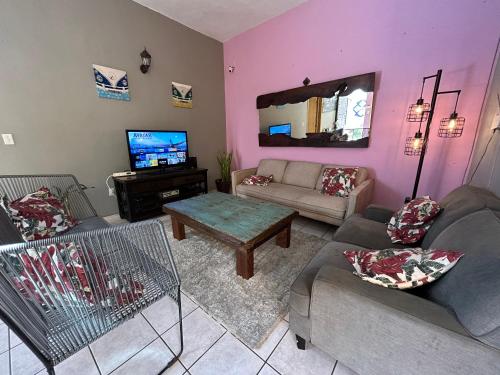 a living room with two couches and a tv at Sofia Hostel Cabo in Cabo San Lucas