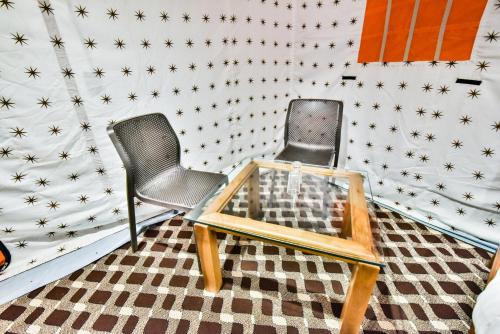 two chairs and a table in a room with stars on the wall at The Posh Camps in Pahalgām