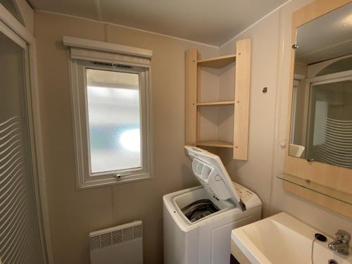 La salle de bains est pourvue d'un lavabo et d'un lave-linge. dans l'établissement Mobil-Home Fouras, 3 pièces, 4 personnes - FR-1-709-61, à Fouras