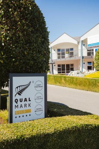 a sign in front of a yard with a building at Radfords on the Lake in Te Anau