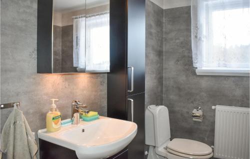 a bathroom with a sink and a toilet at Awesome Home In Tving With Wifi And 3 Bedrooms in Tving
