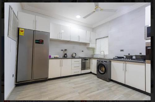 a kitchen with a refrigerator and a washing machine in it at Cozy homes Accra,Ghana in Owuraman