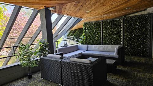 a balcony with a couch and a table and windows at The Cedars Inn Hotel & Convention Centre in Gibsons