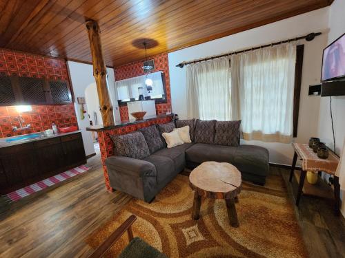 uma sala de estar com um sofá e uma mesa em Chalés Monte Verde em Monte Verde