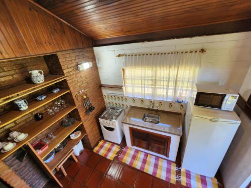 an overhead view of a kitchen with a stove and refrigerator at Chalés Monte Verde in Monte Verde