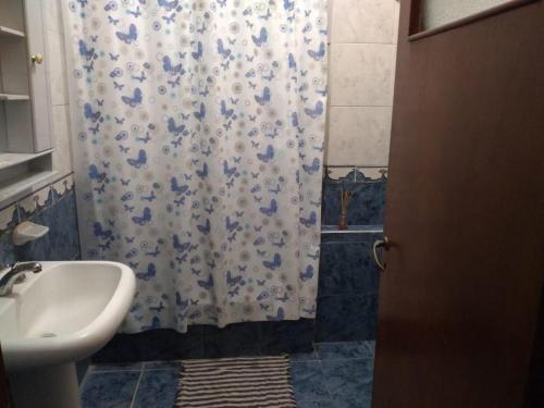 a bathroom with a shower curtain and a sink at Departamento Familiar Amplio y cómodo in Santiago del Estero