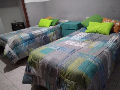 duas camas sentadas uma ao lado da outra num quarto em Departamento Familiar Amplio y cómodo em Santiago del Estero
