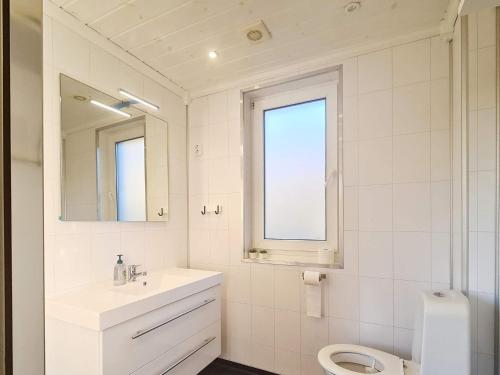 Baño blanco con lavabo y aseo en Holiday home LONEVÅG III, en Lonevåg