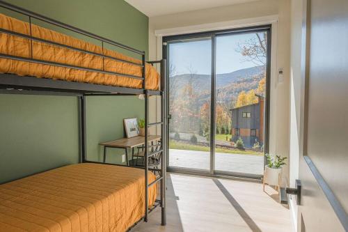 a bedroom with a bunk bed and a large window at Lux Modern Barnhouse Cabin at Hunter Mountain in Hunter