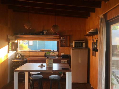 cocina con mesa y nevera en Casa Canela - se reserva con seña, en Punta del Diablo