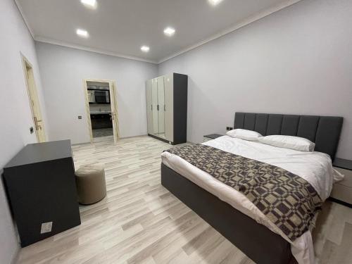 1 dormitorio con 1 cama grande y suelo de madera en Premium VILLA (LUXURY Mansion) en Şamaxı