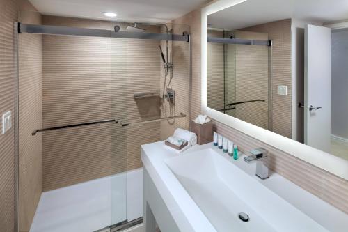 y baño con lavabo blanco y espejo. en The Westin Grand Cayman Seven Mile Beach Resort & Spa en George Town