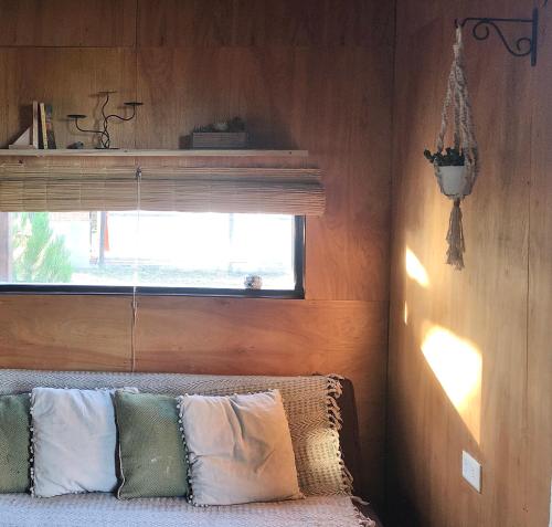 Habitación con ventana y sofá con almohadas en Casa Canela - se reserva con seña, en Punta del Diablo